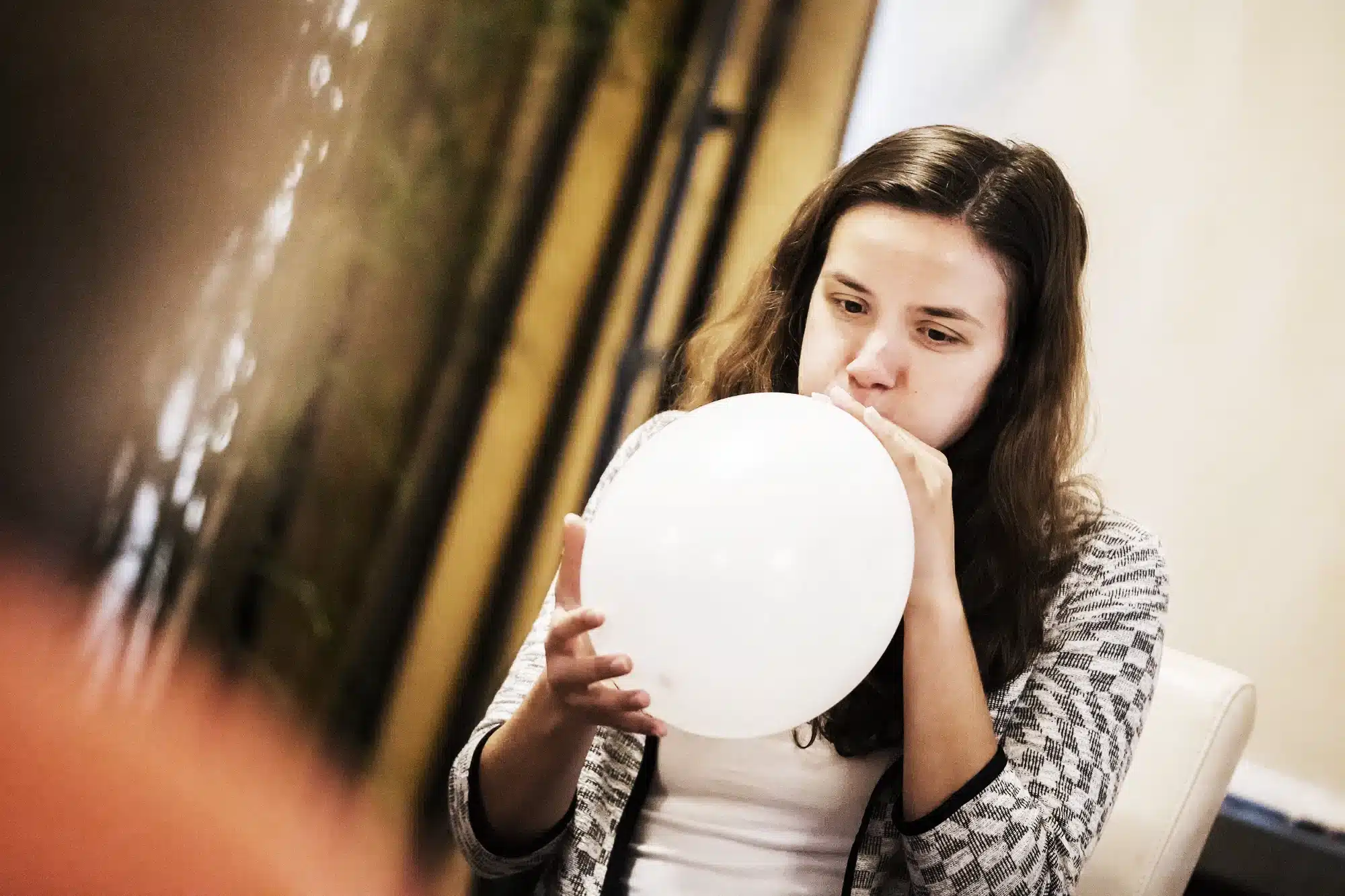 Frau pustet Luftballon auf